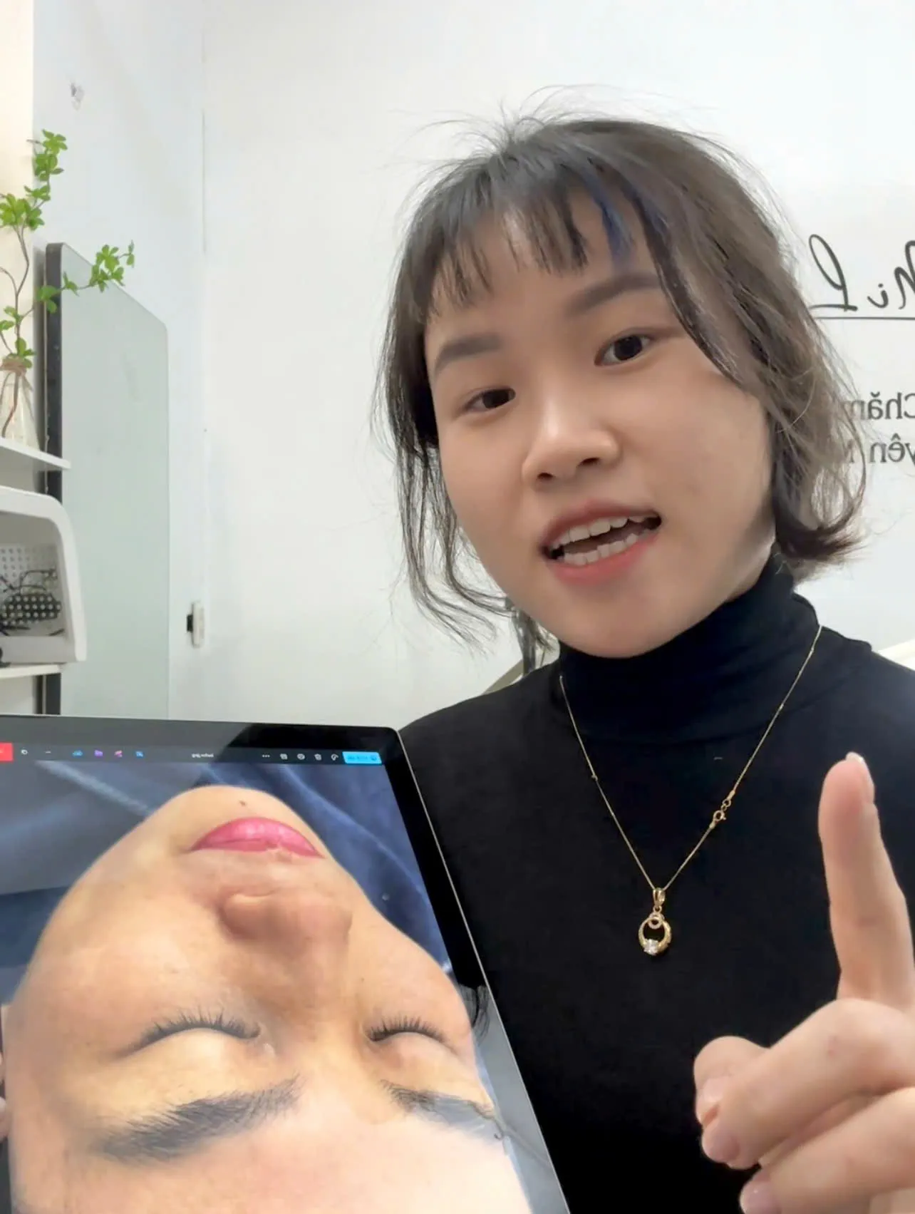 Kỹ thuật viên MiLa cầm máy tính bảng có ảnh da của khách, giải thích tình trạng da trong buổi tư vấn